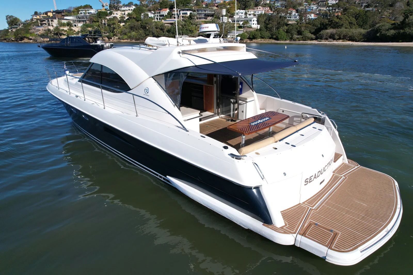 SEADUCTION Riviera charter yacht showing the open saloon and aft entertaining deck on Sydney Harbour